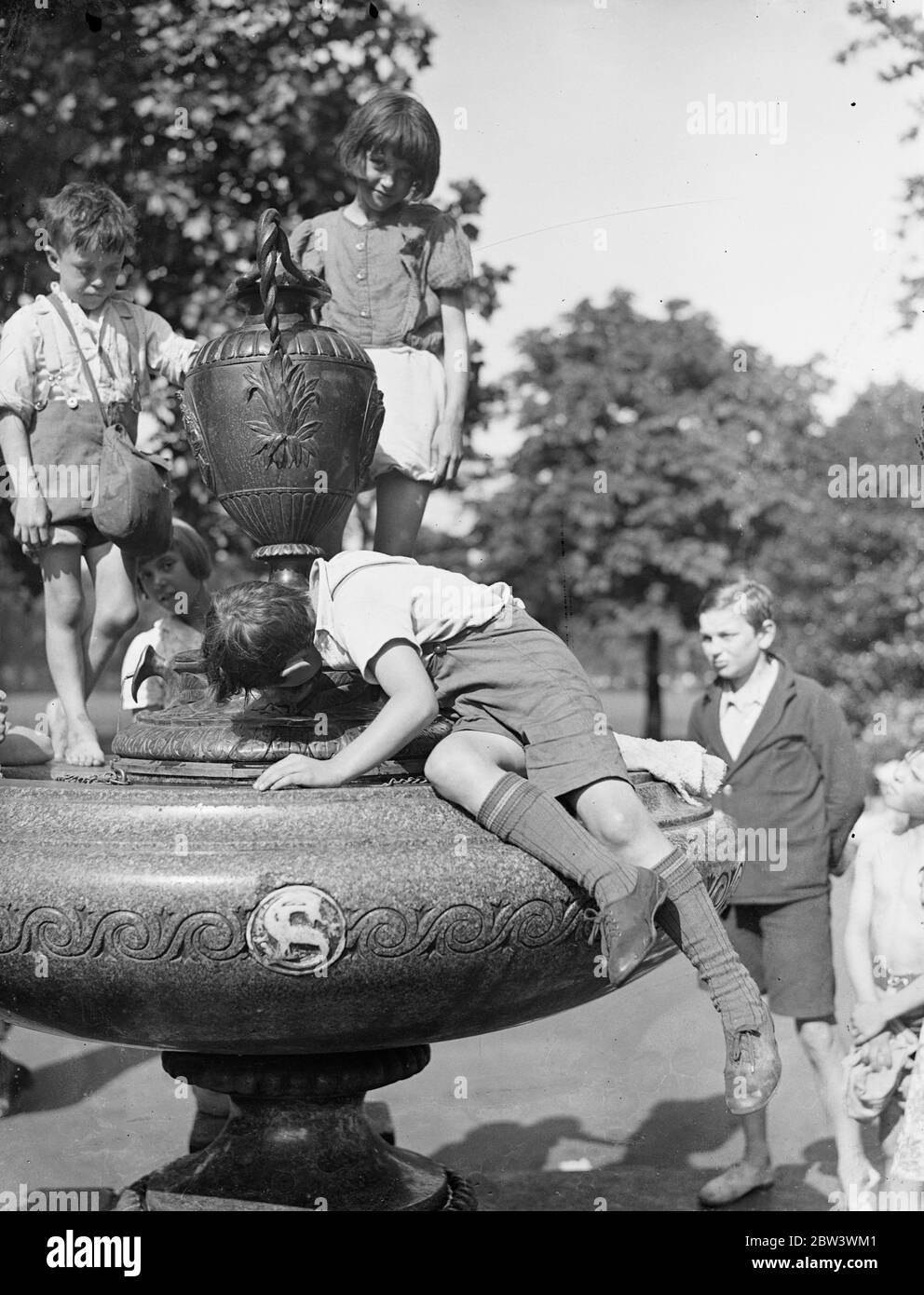 Getting Rid Of A Heat Wave Thirst Photo shows : A fountain in Kennington Park Quenches a small boy ' s thirst in London ' s heat wave . 17 Aug 1936 Stock Photo