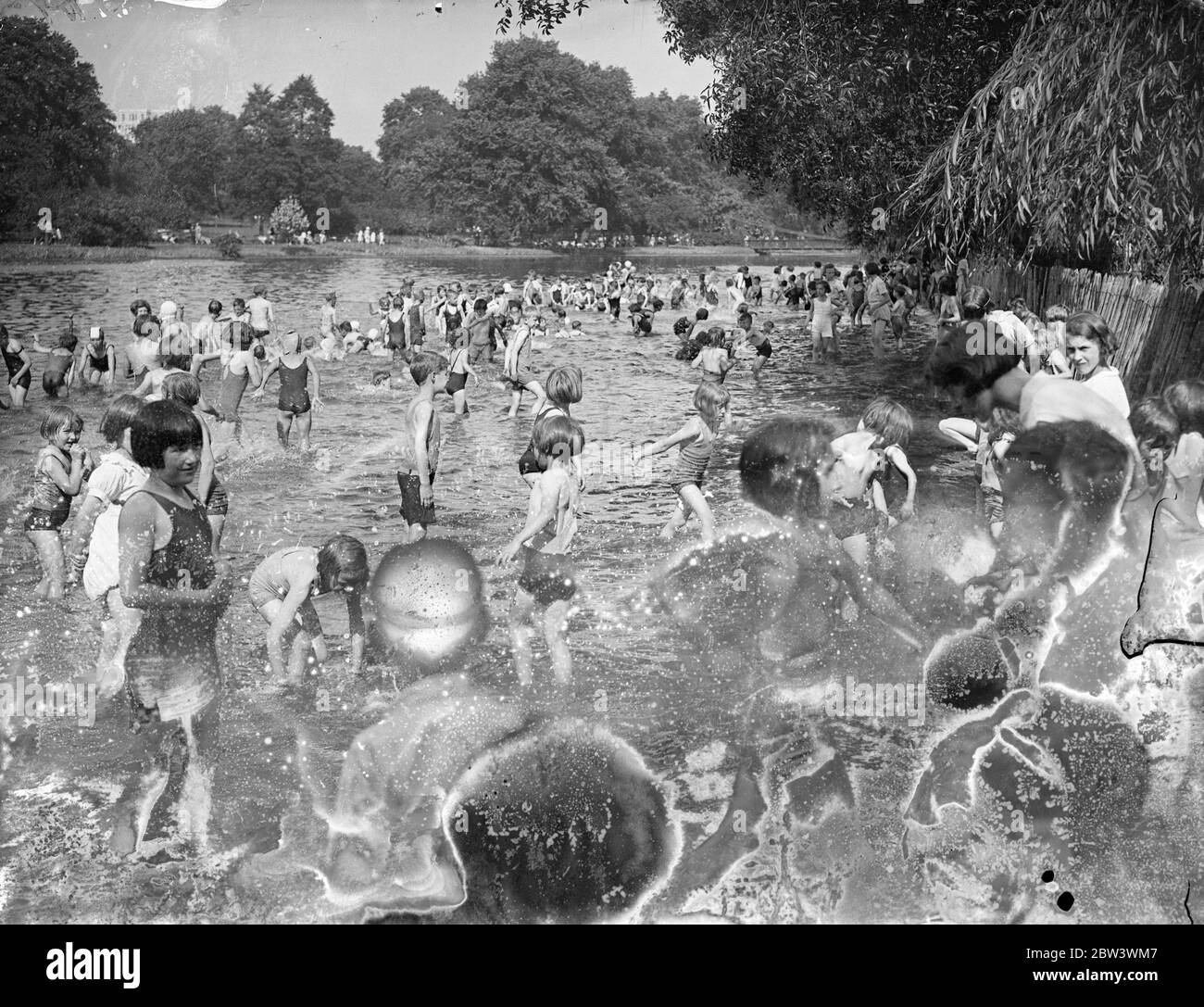 Young Londoners Go A - Paddling In The Heat Wave The heat wave has arrived in time to delight the hearts of thousands of London schoolchildren who are having their summer holidays . St James ' s Park with its swings and other apparatus and its cool paddling pond is attracting crowds of boys and girls . Photo shows : The pond crowded with young paddlers in St . James ' s Park 17 Aug 1936 Stock Photo