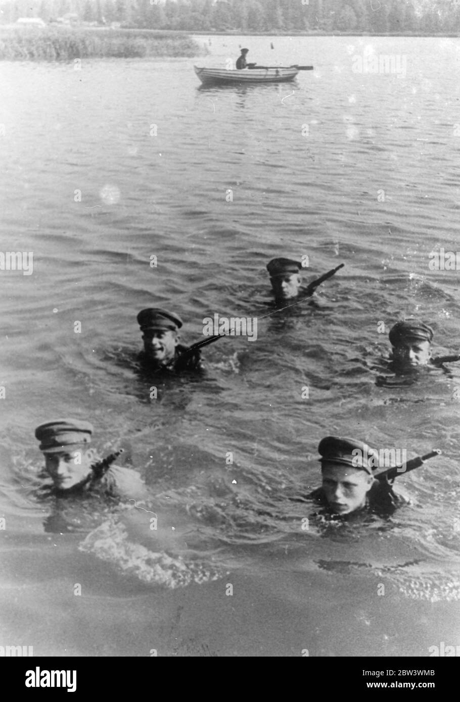 Russia's army takes to the water . With rifles strapped to their backs and wearing full uniform , soldiers of the Red Army swim across a lake during training in Moscow , on on a rowing boat comrade standby in case of emergency . These exercises are designed to give the army greater mobility and the men are being taught to carry full equipment on all possible occasions . 14 August 1936 Stock Photo