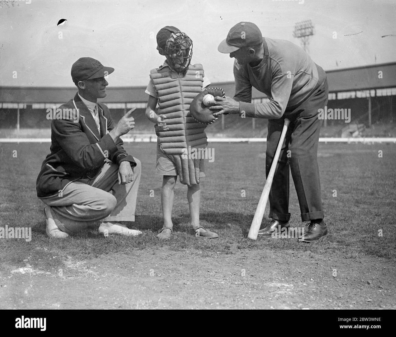 A Hundred London Boys Learn How To Play Baseball At The White City To discover young baseball talent , a hundred boys turned out for tuition at the White City Stadium under the guidance of  Doc  Hayden , the American manager - coach . Small - sized baseball gloves were provided , and the boys received instruction in fieldinf , pitching and batting . Boys who show the highest promise will play next year in a new juniour league . Photo shows :  Doc  Hayden ( right ) giving a small enthusiast some hints on catching . 17 Aug 1936 Stock Photo