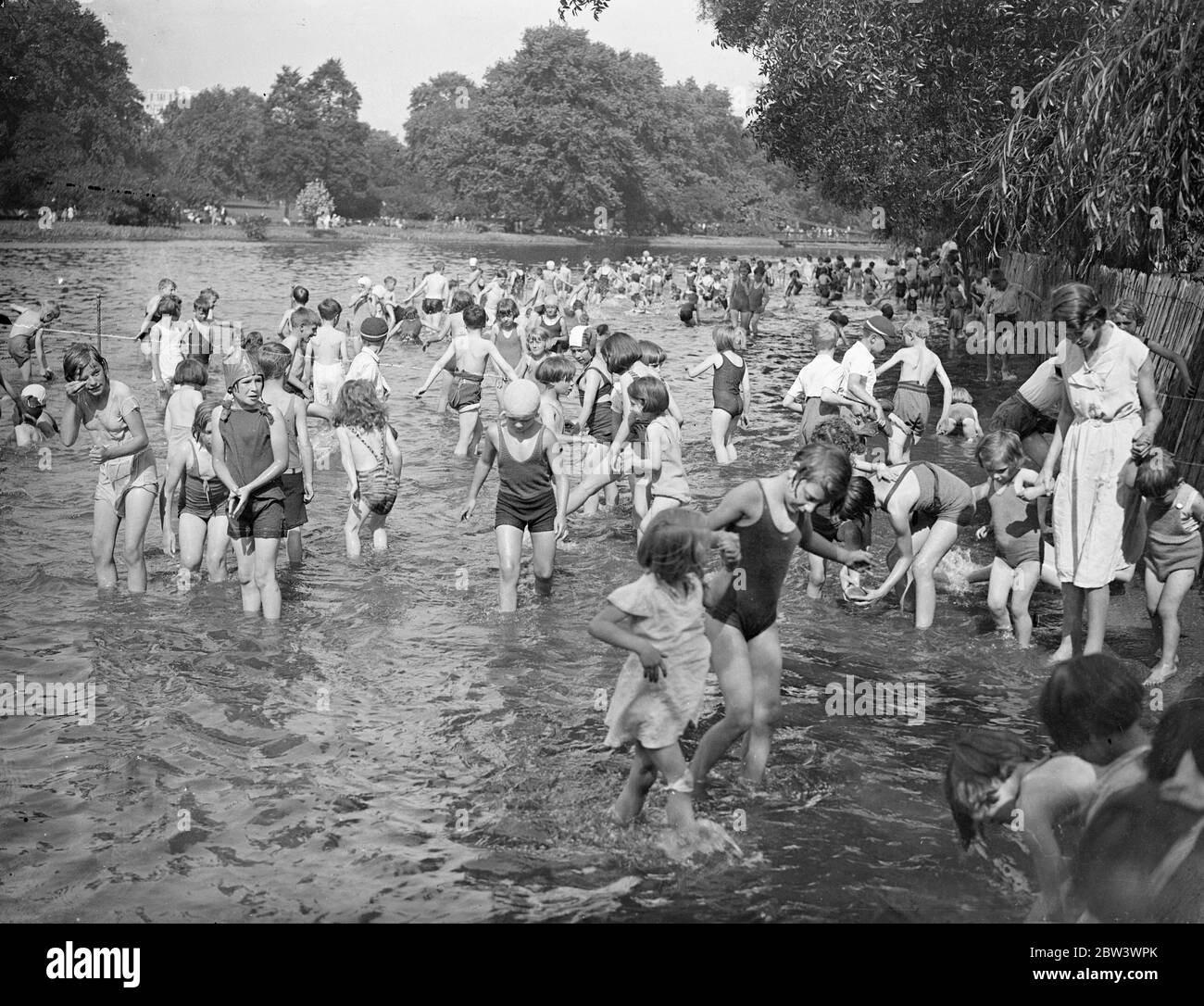 Young Londoners Go A - Paddling In The Heat Wave The heat wave has arrived in time to delight the hearts of thousands of London schoolchildren who are having their summer holidays . St James ' s Park with its swings and other apparatus and its cool paddling pond is attracting crowds of boys and girls . Photo shows : The pond crowded with young paddlers in St . James ' s Park 17 Aug 1936 Stock Photo