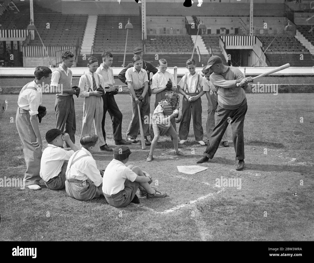 A Hundred London Boys Learn How To Play Baseball At The White City To discover young baseball talent , a hundred boys turned out for tuition at the White City Stadium under the guidance of  Doc  Hayden , the American manager - coach . Small - sized baseball gloves were provided , and the boys received instruction in fieldinf , pitching and batting . Boys who show the highest promise will play next year in a new juniour league . Photo shows :  Doc  Hayden showing the boys how to strike . 17 Aug 1936 Stock Photo