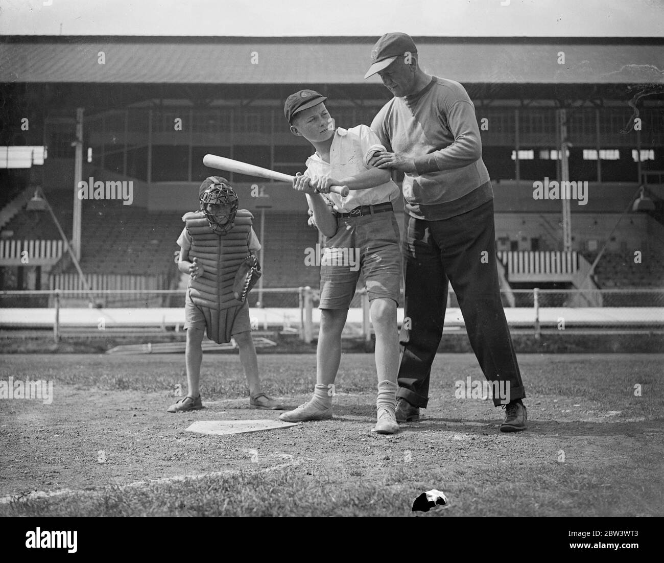 A Hundred London Boys Learn How To Play Baseball At The White City To discover young baseball talent , a hundred boys turned out for tuition at the White City Stadium under the guidance of  Doc  Hayden , the American manager - coach . Small - sized baseball gloves were provided , and the boys received instruction in fieldinf , pitching and batting . Boys who show the highest promise will play next year in a new juniour league . Photo shows :  Doc  Hayden giving instruction in batting . 17 Aug 1936 Stock Photo