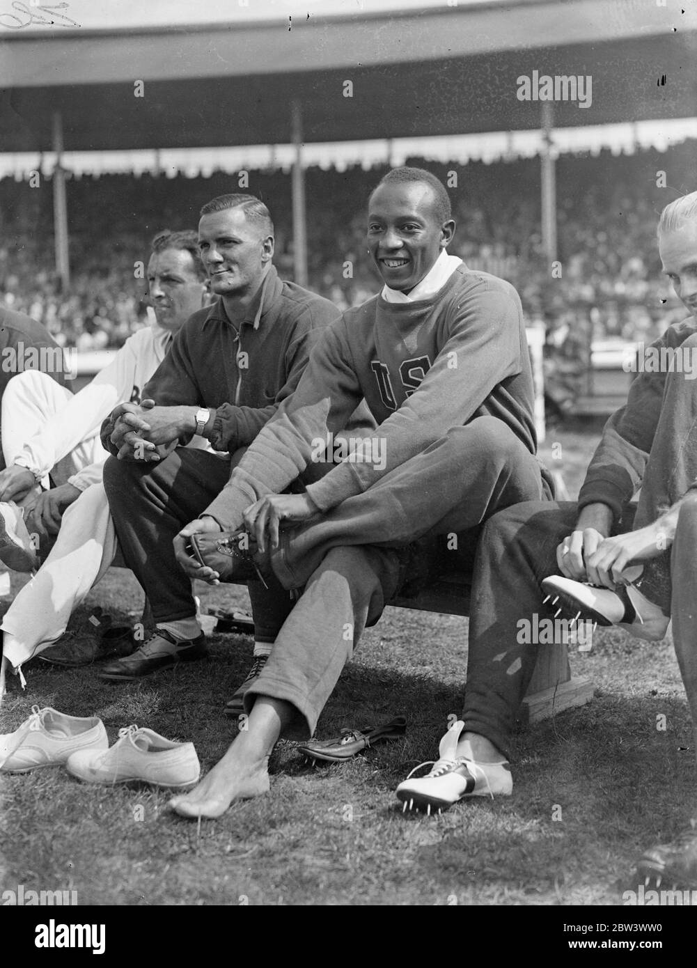 Jesse Owens , Olympic ' flyer ' , takes part in United States versus the Empire match at White City . The Olympic record-breaking athletes of the United States , including Jesse Owens , winner of the three Olympic gold medals , opposed athletes of the British Empire in a meeting at the White City , London . The contest was a series of relay and team races , with six field events . Photo shows , Jesse Owens ( USA ) that Iran is running shoes at the White City . 15 August 1936 Stock Photo