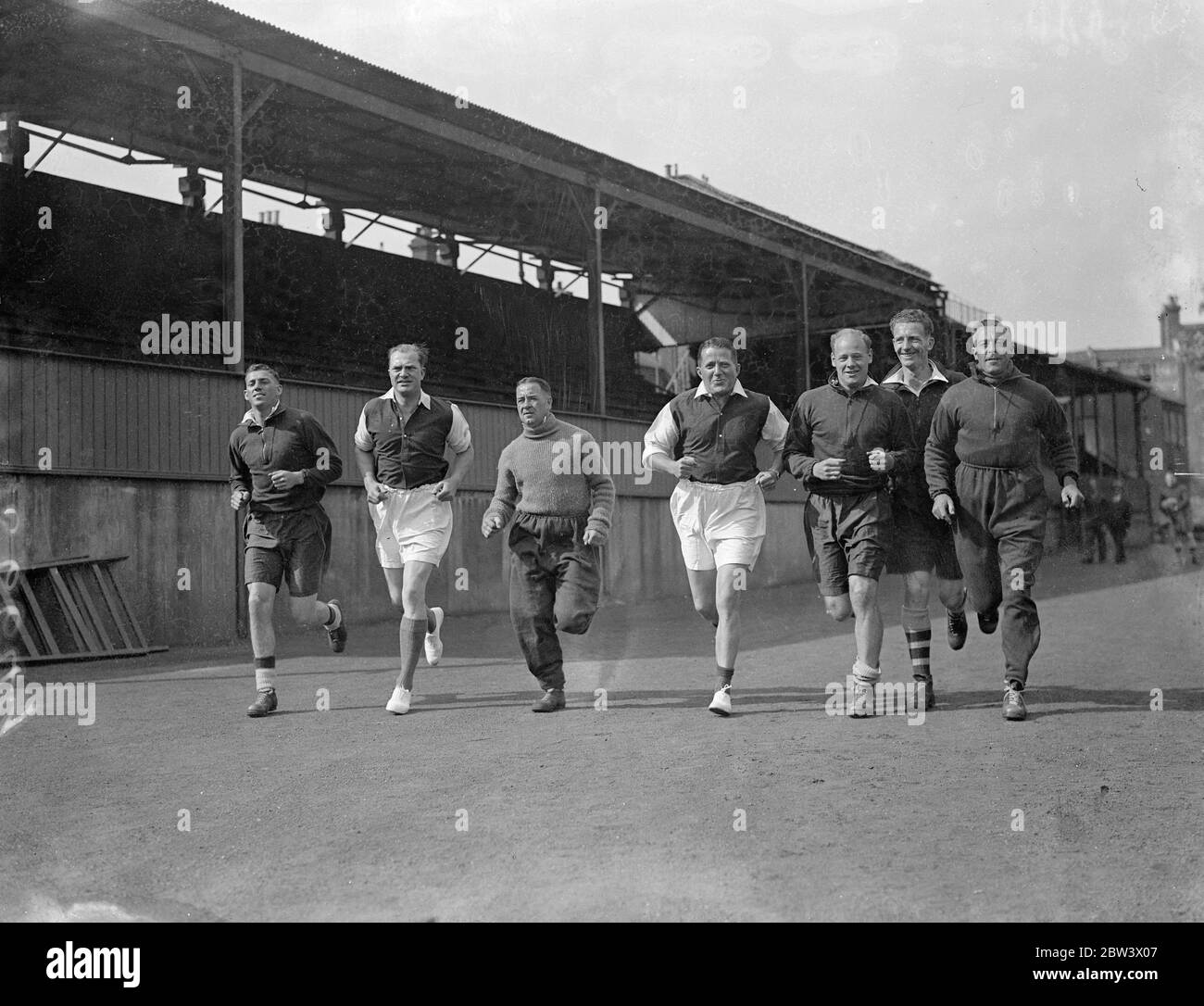 Tommy Rose and Charles Scott , the airmen , reported for duty to Tom Whittaker , the Arsenal Football trainer at the Arsenal training ground , Tufnell Park , to be made fighting fit for next month ' s England Johannesburg air race . The airmen are going into training with the Arsenal footballers . Photo shows , Rose and Scott running with Arsenal players at Tufnell Park ground , right to left , Joe Hulme , Grayston Male , Rose Alex James , Scott 27 August 1936 . Original caption from negative Stock Photo