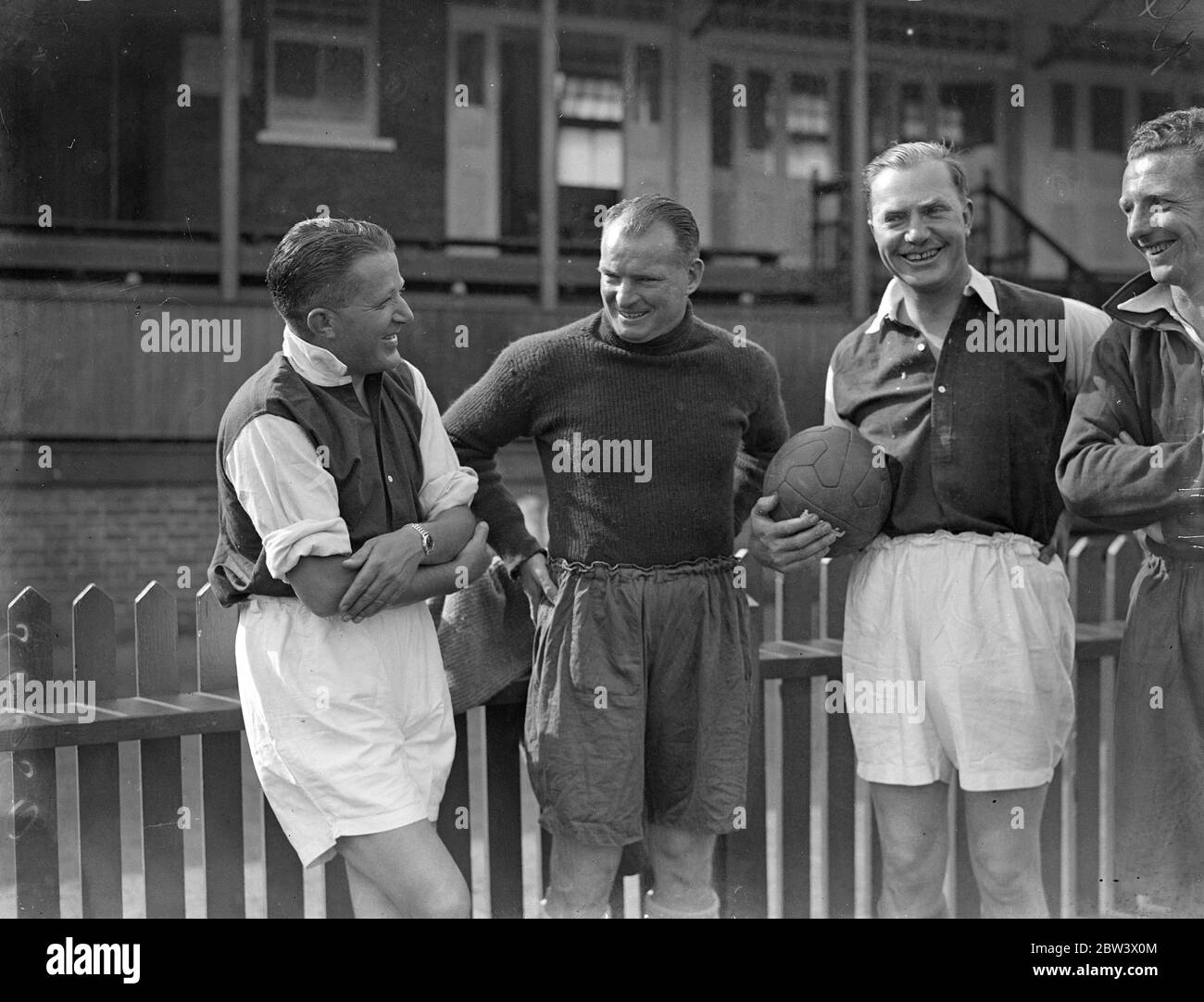 Tommy Rose and Charles Scott , the airmen , reported for duty to Tom Whittaker , the Arsenal Football trainer at the Arsenal training ground , Tufnell Park , to be made fighting fit for next month ' s England , Johannesburg air race . The airmen are going into training with the Arsenal footballers . Photo shows , Tommy Rose ( left ) and Charles Scott withTom Whittaker at the Tufnell Park ground . 27 August 1936 . Original caption from negative Stock Photo