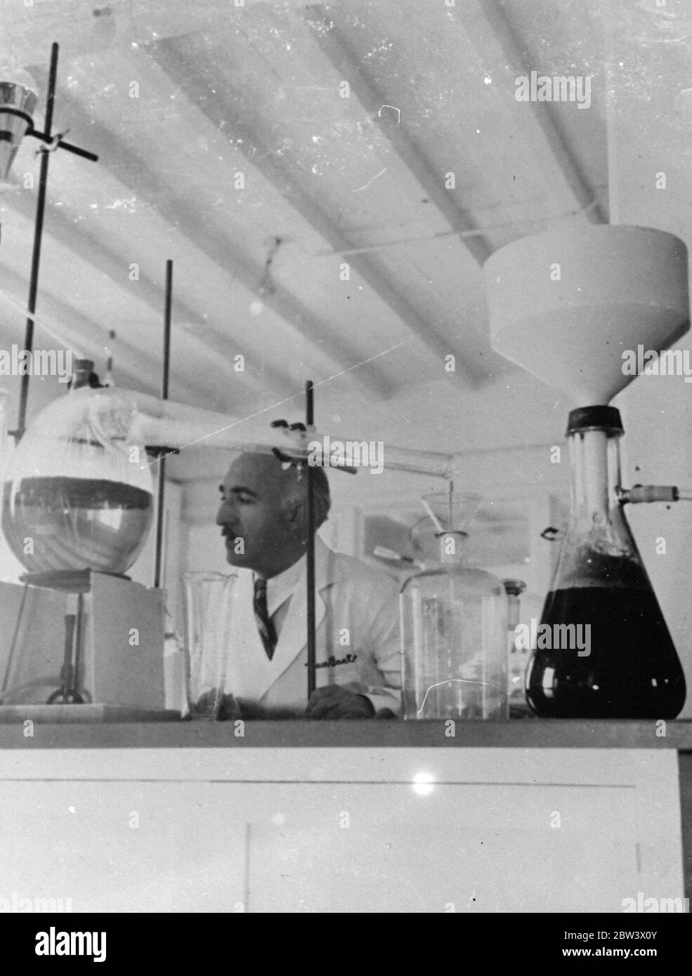 Dr A T Frascati an American scientist . Making perfume from crushed fruit . Photo shows , demonstrating the 4 step in the process , all in jars and acids are removed and the essence is then ready for blending with certain base oils . Original caption from negative Stock Photo