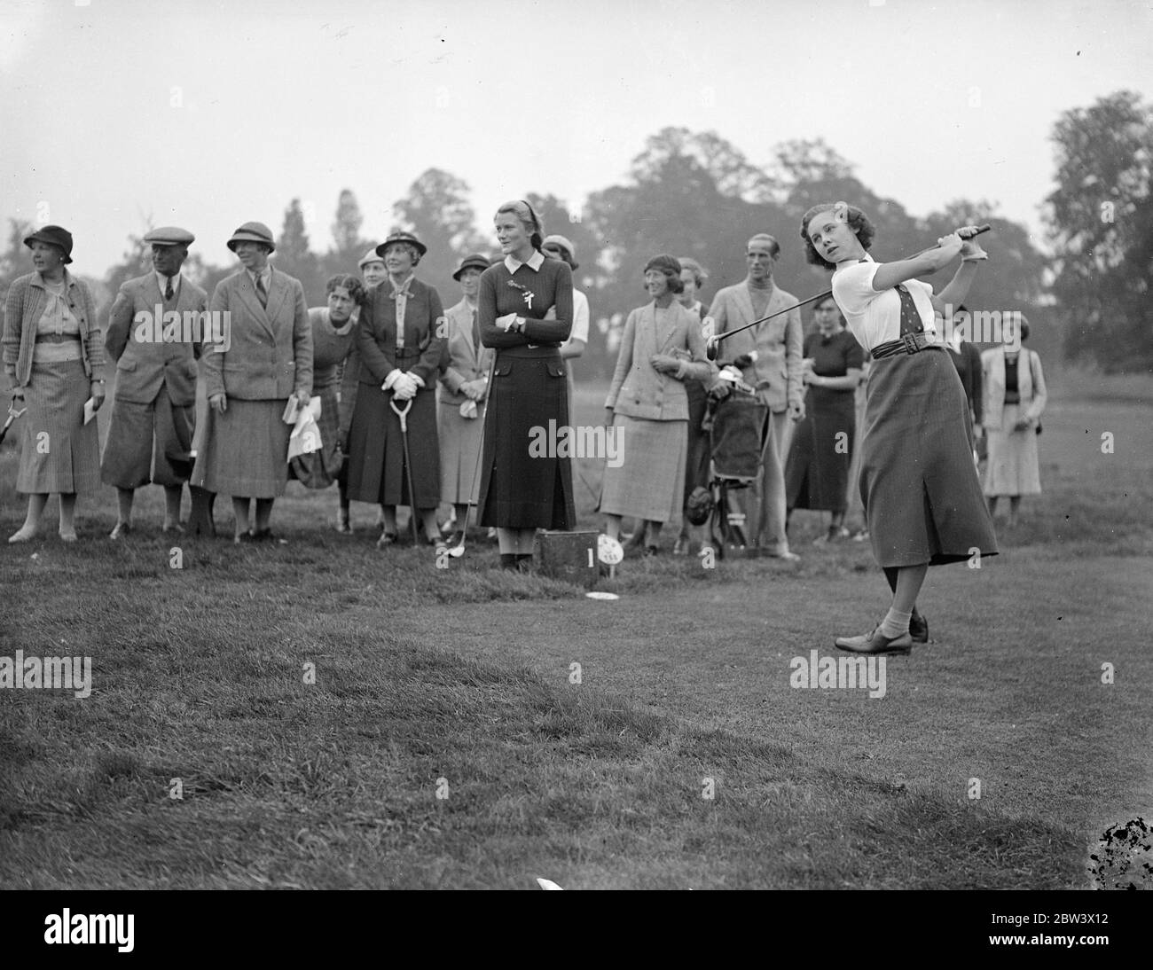 Girls open golf championship at Stoke Poges . The opening matches in the Girls Open golf championship are being played at Stoke Poges . Britian ' s leading girl players are being challenged by two French competitors Lally and Sonia Vagliano , and one South African , Miss Daphne Martyn from Port Elizabeth . Photo shows , Miss Monica Parnell driving from the first tee watched by her opponent , Miss Angela Noble ( by tee box ) and a gallery . 9 September 1936 Original caption from negative Stock Photo