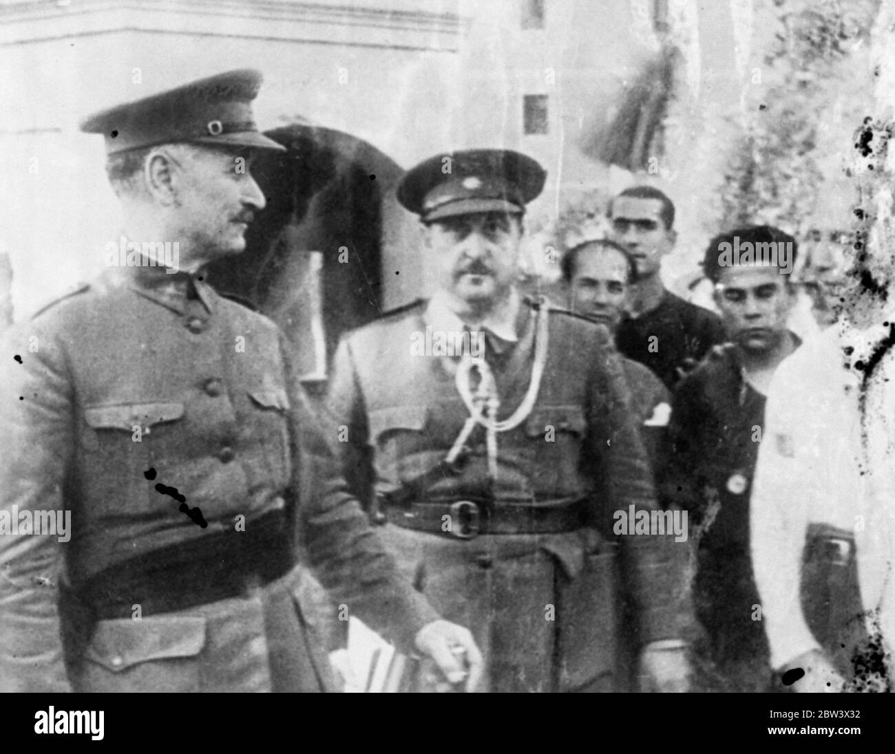 General De Llano Smiles - Rebel Chief Is Grim Photo shows : General Gonzalo Queipo de Llano , rebel commander in Seville ( left ) wears a smile that draws no response from his chief , General Franco ( centre ) at one of their meetings 25 Aug 1936 Original caption from negative Stock Photo