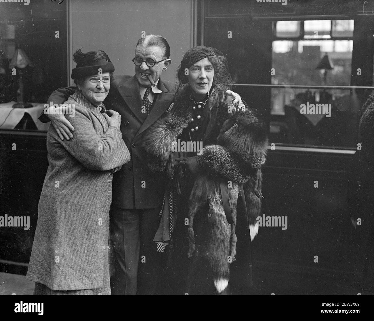 Woolsey , of Wheeler and Woolsey , welcome his wife and mother to London . Robert Woolsey , of Wheeler and Woolsey , the film comedian , was at Waterloo Station to welcome his wife and mother when they arrived on the ' Normandie ' boat train from America . Photo shows , Robert Woolsey , smoking a cigar as usual , with his wife , and mother on their arrival at Waterloo . 24 August 1936 Original caption from negative Stock Photo