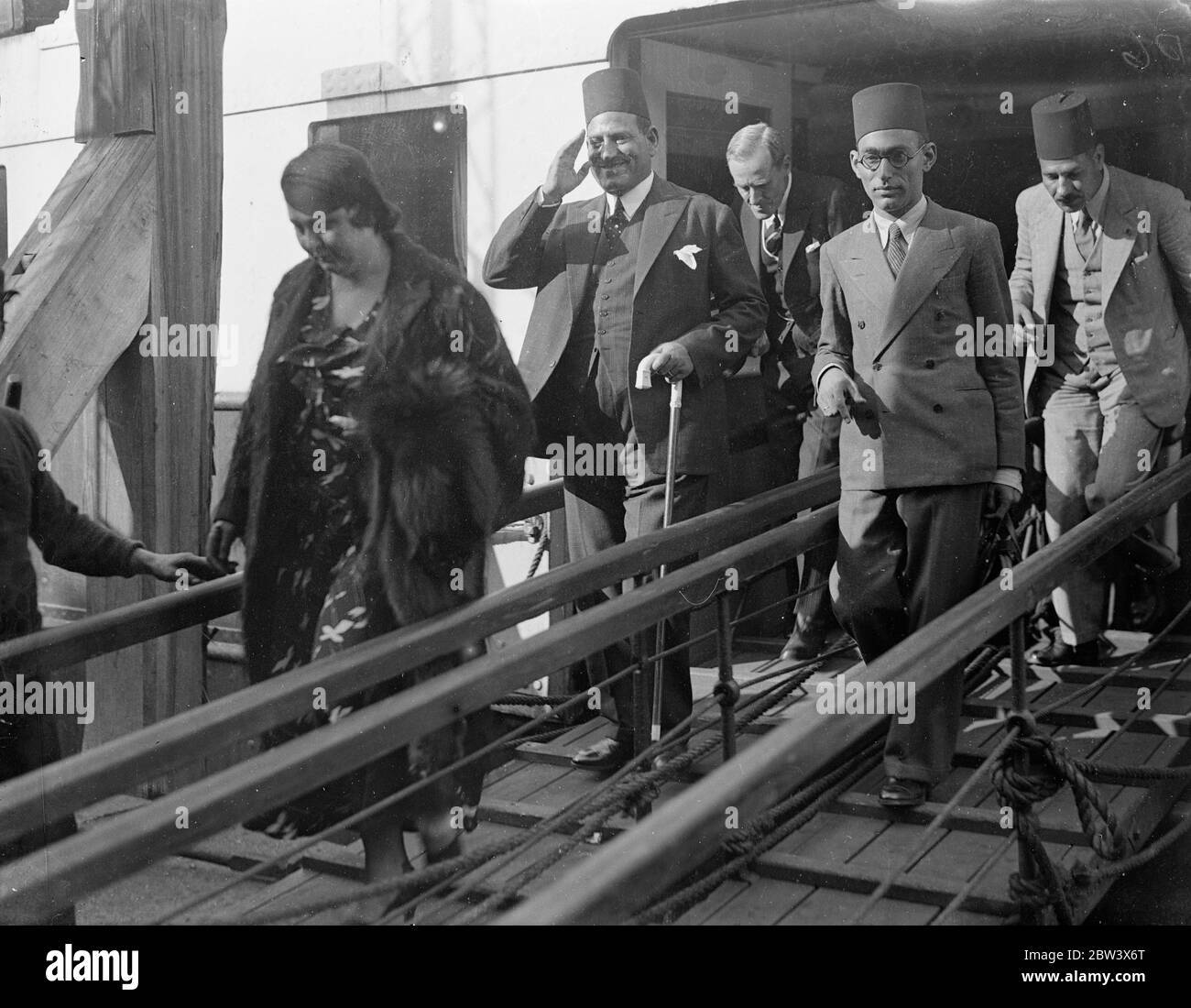 Nahas Pasha and Egyptian delegation arrive at Dover to sign treaty . Led by Wafdist Premier , Nahas Pasha , the Egyptian delegation of 13 which is to take part in the signing of the new Anglo Egyptian Treaty on Wednesday arrived at Dover . The delgation was recieved by Major E N S Crankshaw on behalf of the Minister in Charge of Government Hospitality . Photo shows , Nahas Pasha saluting as he went ashore at Dover preceded by his wife . 23 August 1936 Original caption from negative Stock Photo