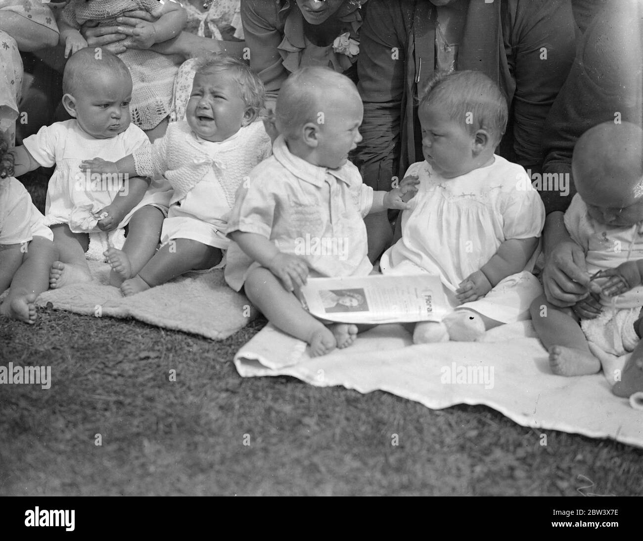 Tell that to the marines ! . A competitor ( right ) signifies sceptism when a rival tells a particularly tall story at the Baby Show held at Oxford in connection with the annual Floral fete organised by the Great Western Railway Social and Educational Union . 22 August 1936 Original caption from negative Stock Photo