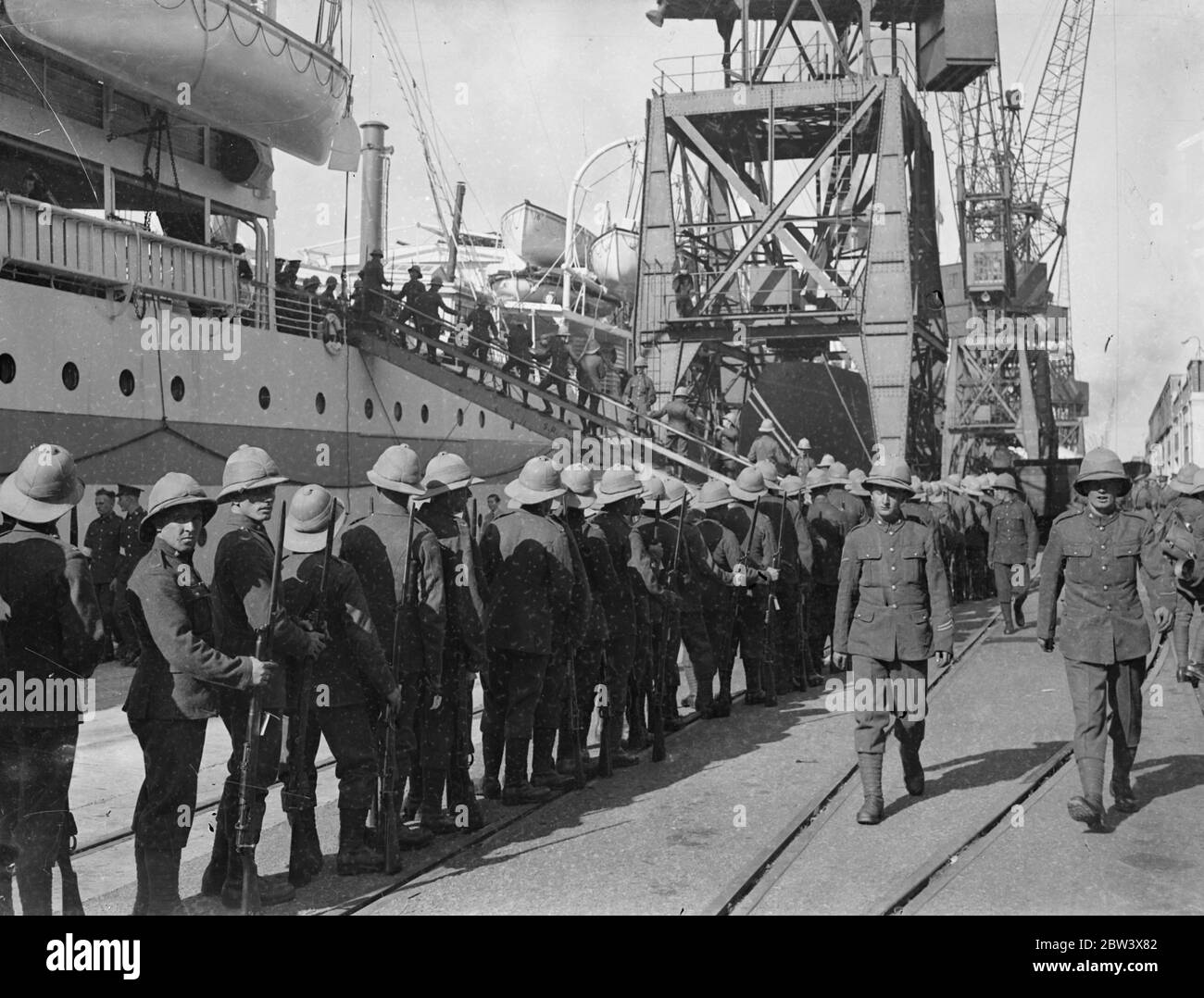 Two ships leave with troops for Palestine . Further detachment troops member of the Royal Ordinance Corps and the East Yorkshire's Regiment , left Southampton aboard the troopship Nevass and the liner Laurentic for Palestine . Photo shows , men of the East Yorkshire Regiment handing up their kit on Nevass as the Royal Army ordnance court attachment marches past to the Laurentic . 14 September 1936 Stock Photo
