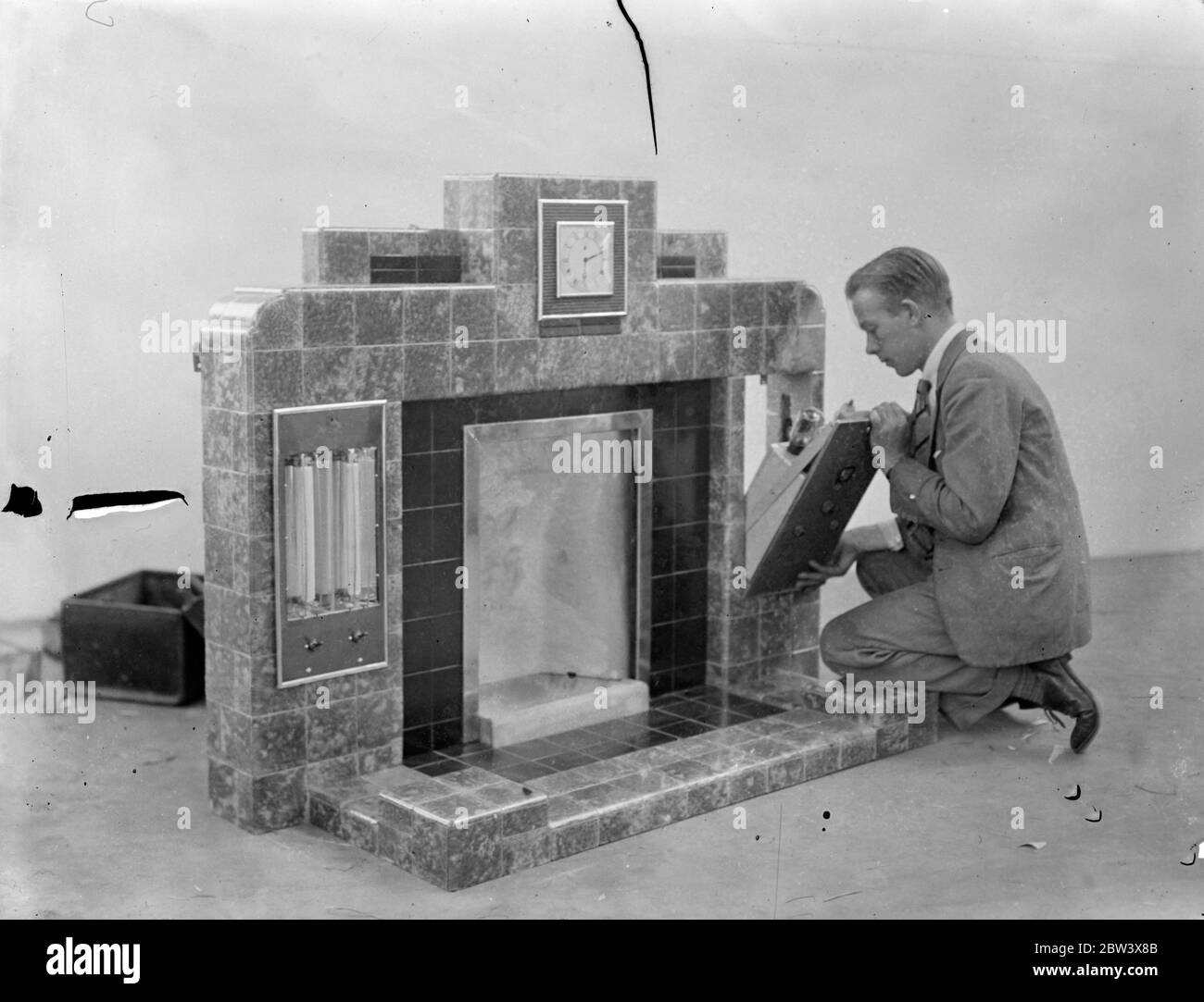 Real Fireside radio at building exhibition . Three hundred and fifty exhibitors drawn from all branches of the building industry showing that exhibits at the 20th biennial building exhibition to be open at the Olympia Earl Stanhope , first Commissioner of Works on Wednesday . Many novelties for the home on view . Photo shows , fitting the radio set into the radiomant , a combined mantelpiece and radio . 14 September 1936 Stock Photo