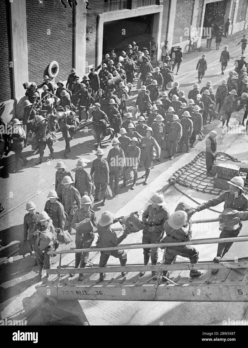 Two ships leave with troops for Palestine . Further detachment troops member of the Royal Ordinance Corps and the East Yorkshire's Regiment , left Southampton aboard the troopship Nevass and the liner Laurentic for Palestine . Photo shows , men of the East Yorkshire Regiment handing up their kit on Nevass as the Royal Army ordnance court attachment marches past to the Laurentic . 14 September 1936 Stock Photo