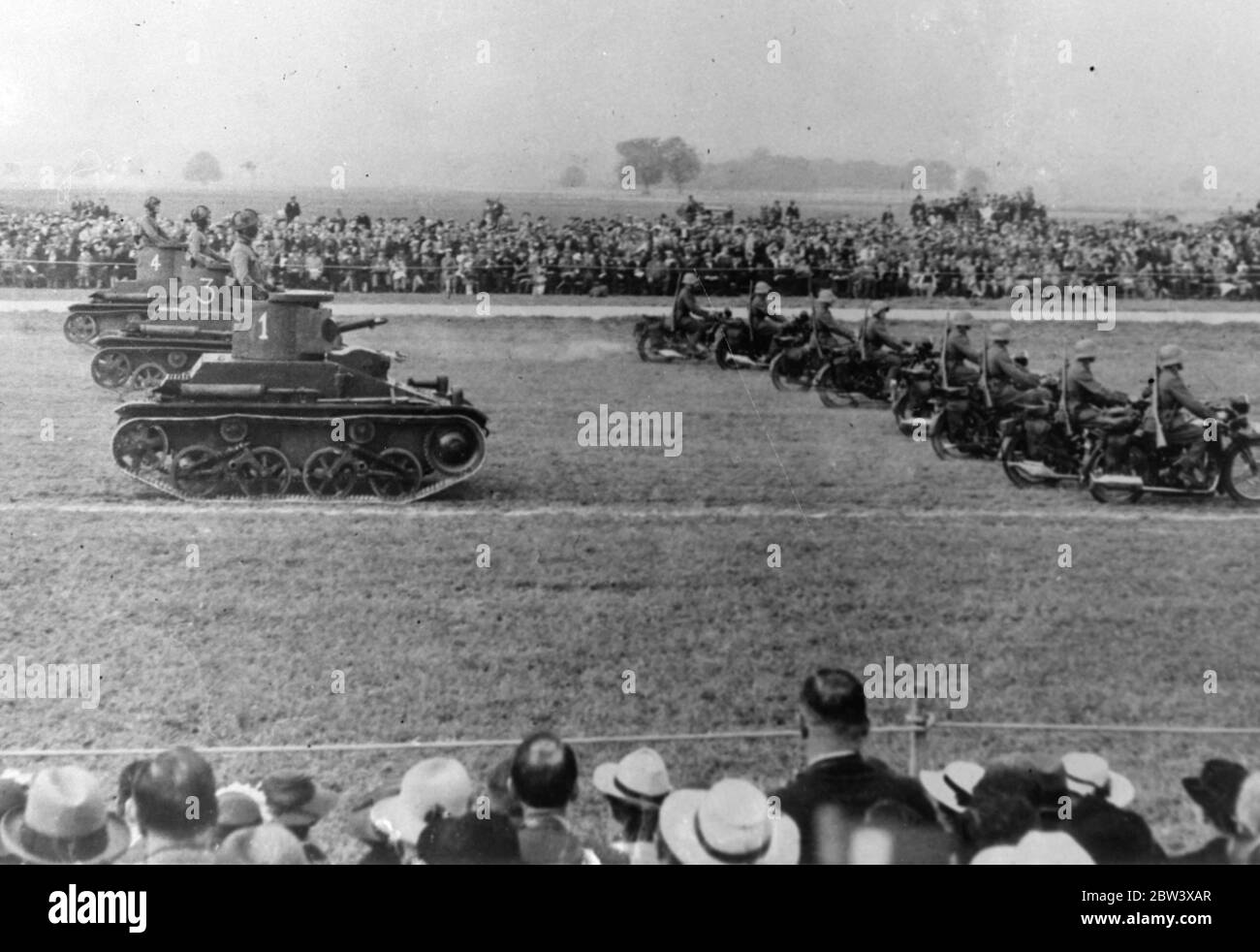 Switzerland ' s up to date army on parade . The efficiency of Switzerland ' s highly mechanised army was demonstrated when the 2 Division marched past military chiefs near Utzendorf in connection with the Swiss Army manoeuvres . Photo shows , tanks and motorcycle troops in the parade . 12 September 1936 Stock Photo