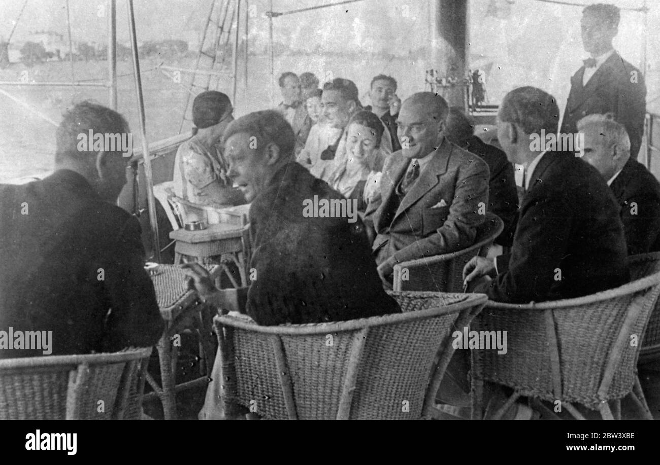 The King ' s intimate talk with Ataturk . New Picture . These pictures , just received in London , show the intimacy with which King Edward VIII chatted with Kemal Ataturk , the Turkish Dictator , when the King watched from the President ' s yacht , Ertogrul a special regatta held in his honour just before he left Istanbul . The King joined the President in drinking Turkish coffee . Photo shows , King Edward talking to a member of the party aboard the Ertogrul as Ataturk smiles on right . 11 September 1936 Stock Photo