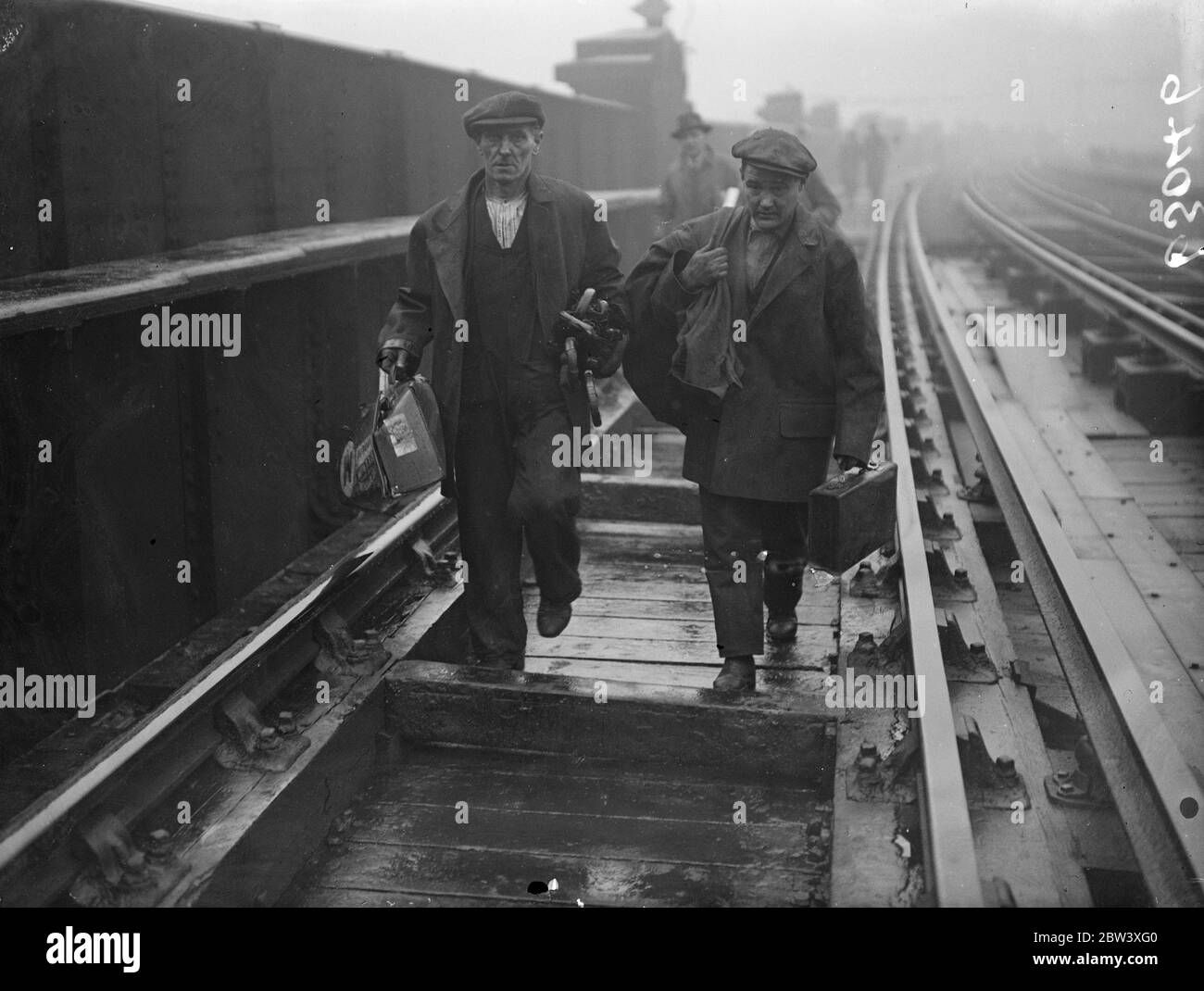 12 people were killed and nearly 50 injured when the electric trains collided head-on at Fourspan Bridge between Queen's Road and Battersea Park Station. Photo shows: Men carrying away the belongings of injured passengers. 2 April 1937 Stock Photo