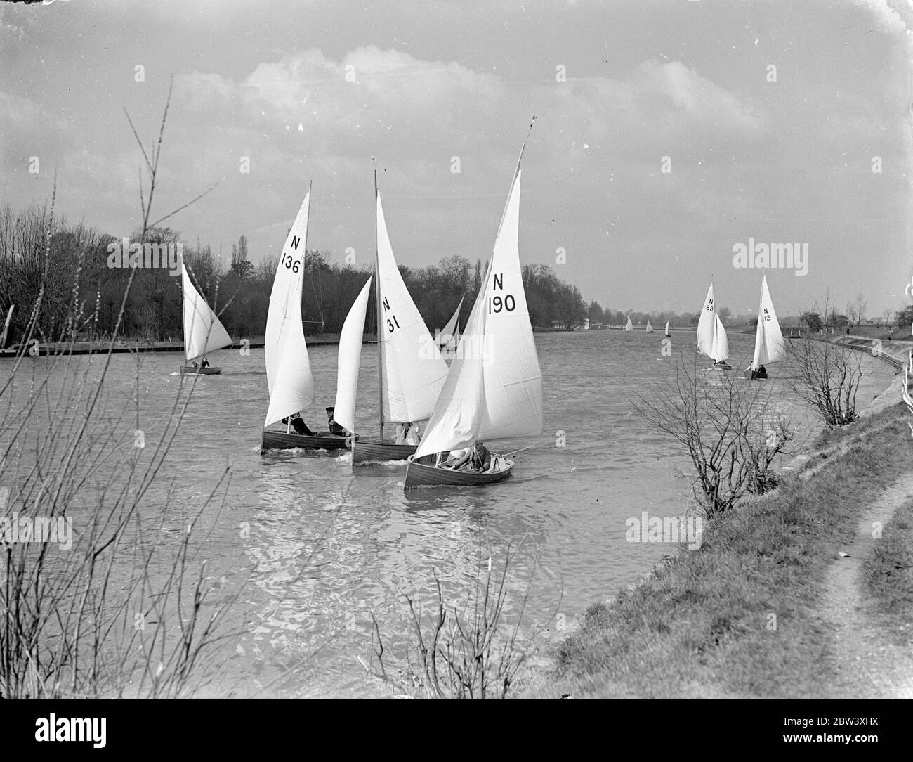 The Tamesis Sailing Club held an Easter Saturday yacht meeting at Teddington. A stiff breeze provides plenty of fuel for the sails and a ducking for some competitors. Photo shows: yachts make an attractive seascape for land bound Londoners as they scud before the breeze at Teddington 27th March 1937 Stock Photo
