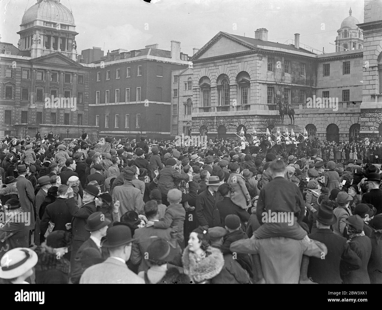 Large Easter Monday crowds watched the Changing of the Guard. The ceremony took place on the parade ground because Coronation stands now occupy the courtyard where it usually takes place. Photo shows: the enormous crowd watching the guard change on the Horse Guards Parade ground. 29 March 1937 Stock Photo