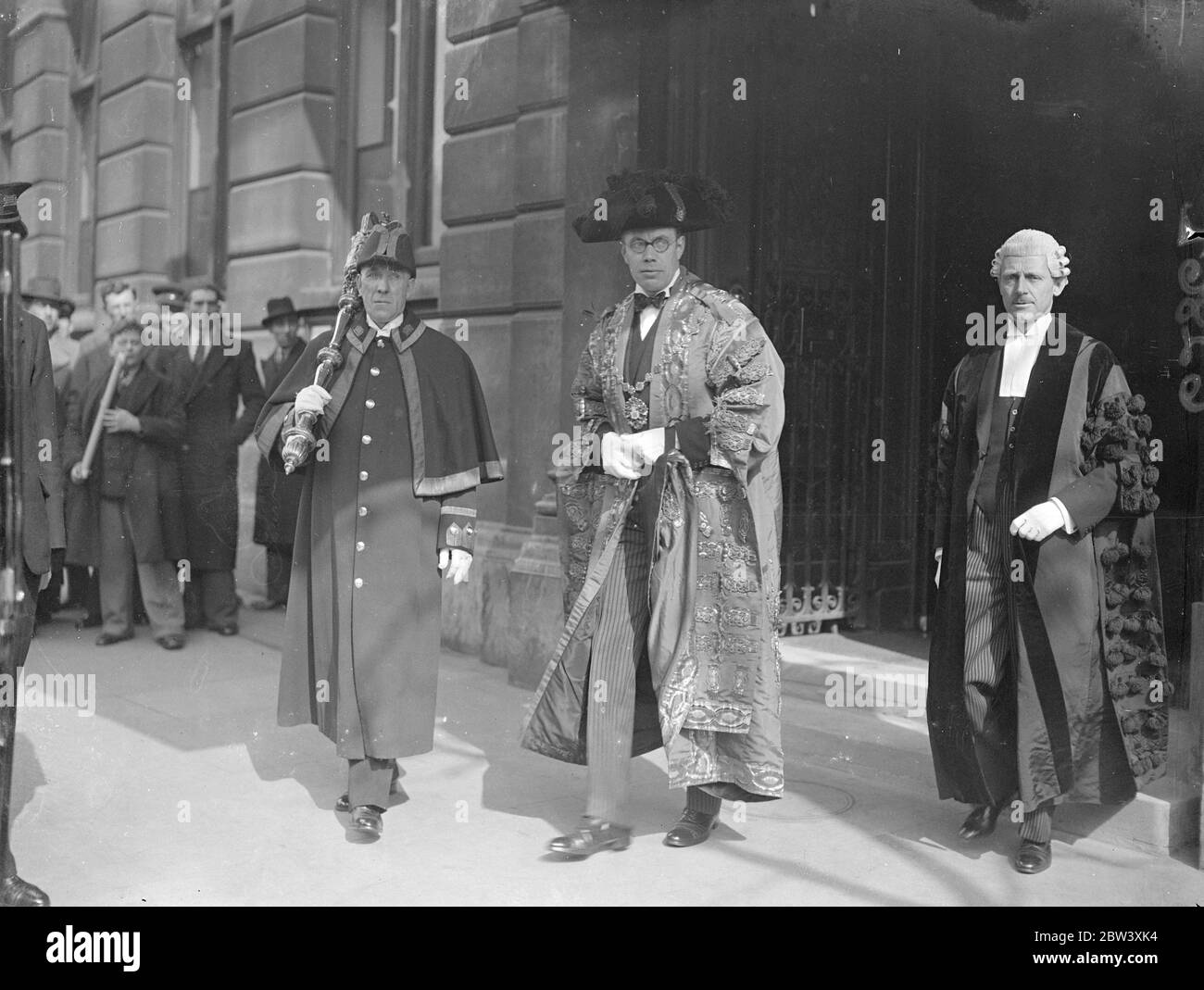 Led by the Mayor, the Honourable Arthur Howard, a deputation of members of the Westminster City Council left the Westminster City Hall in Charing Cross Road to present a loyal address to the King at Buckingham Palace. Photo shows the Mayor, the Honourable Arthur Howard, in his robes, leaving Westminster City Hall with members of the delegation for the Palace. March 25th 1937 Stock Photo