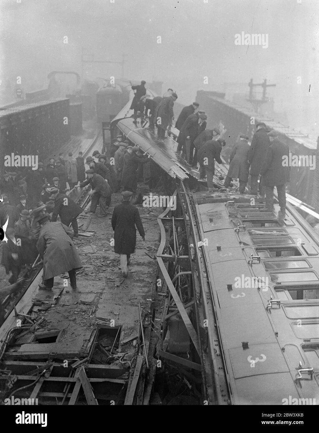 12 people were killed and nearly 50 injured when the electric trains collided head-on at Fourspan Bridge between Queen's Road and Battersea Park Station. Coaches were telescoped and overturned. Photo shows: A general view at the scene of the smash. Pictures taken a few minutes after the crash. 2 April 1937 Stock Photo
