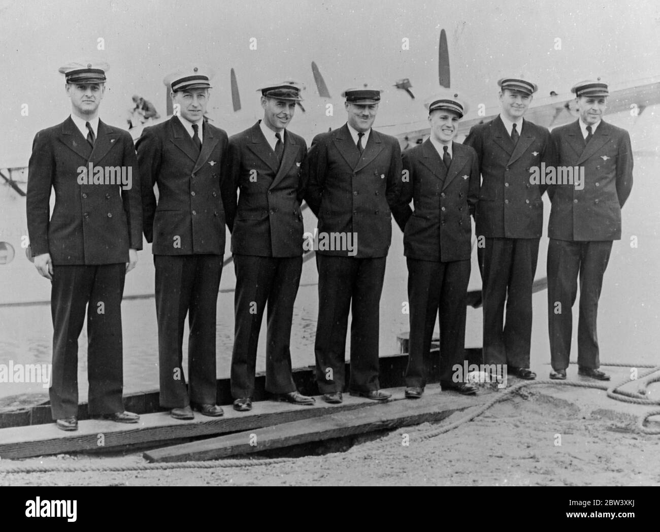To blaze a new air trail along the 7000 miles route from California to Australia, the newest giant Sikorsky Clipper flying boat left Alameda, California, on her flight across the Pacific Ocean photo shows the crew of the Clipper plane on departure from Alameda. From left - Ivan Parker (Pruser) ; William M Holsenbeck (Junior Officer) ; Thomas R Runnels (Radio) ; Victor Wright (Flight Engineer) ; Harry A Canaday (Navigator) ; Frank Briggs (First Officer) ; Captain Edwin C Musick (Commander). March 1937 Stock Photo