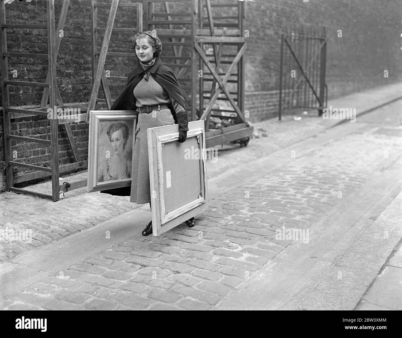 Woman artist takes paintings to Royal Academy . Women artists were among those who took their paintings to the Royal Academy , Burlington House , on sending in day for oils . Photo shows , Miss Peggy Watts arriving with two of her works . 30 March 1937 Stock Photo