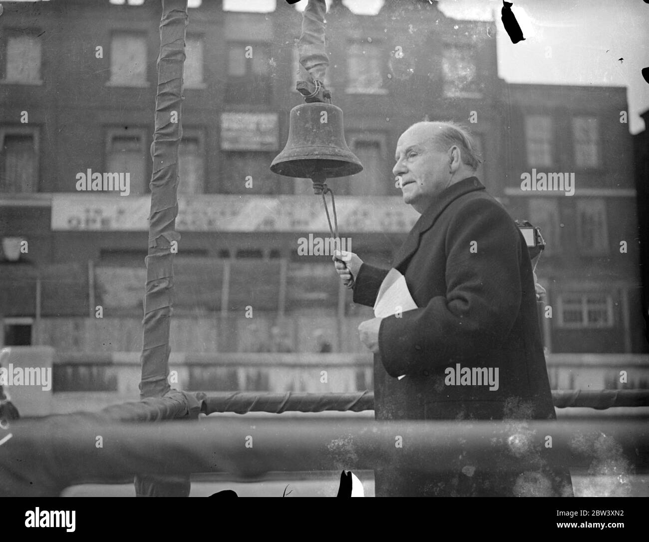 Lord Wakefield inaugurates Tower Hill demolition work . Lord Wakefield presided at the inauguration of demolition work on Tower Hill under the Tower Hill Improvement Scheme . Lord Wakefield rang a bell as a signal for the ' blowing up ' of the old buildings . Photo shows , Lord Wakefield ringing the bell . 18 March 1937 Stock Photo