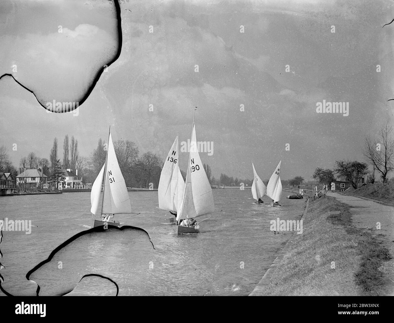 The Tamesis Sailing Club held an Easter Saturday yacht meeting at Teddington. A stiff breeze provides plenty of fuel for the sails and a ducking for some competitors. Photo shows: yachts make an attractive seascape for land bound Londoners as they scud before the breeze at Teddington 27th March 1937 Stock Photo