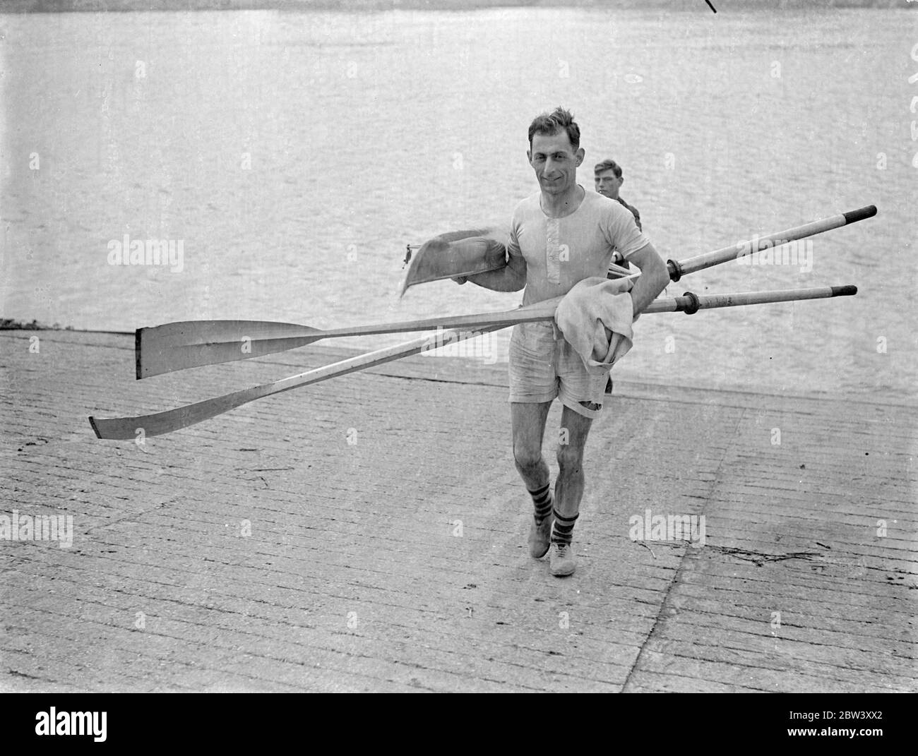 Lou Barry trains to regain sculling title . Lou Barry , the former holder , is training for an attempt to regain the English professinal sculling championship from Eric Phelps , the present champion . The race will be run on Easter Monday over the Putney Mortlake course . Photo shows , Lou Barry bringing in his boat after practise at Barnes . 12 March 1937 Stock Photo