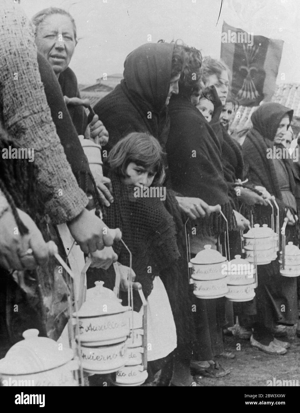She was hungry , too . A little girl of Salamanca huddled in her shawl against the cold as she waited in a long queue to receive food from the Winter Help organisation formed by Fascists in the part of Spain fuled by General Franco to relieve the distress of the civil war . 10 March 1937 Stock Photo