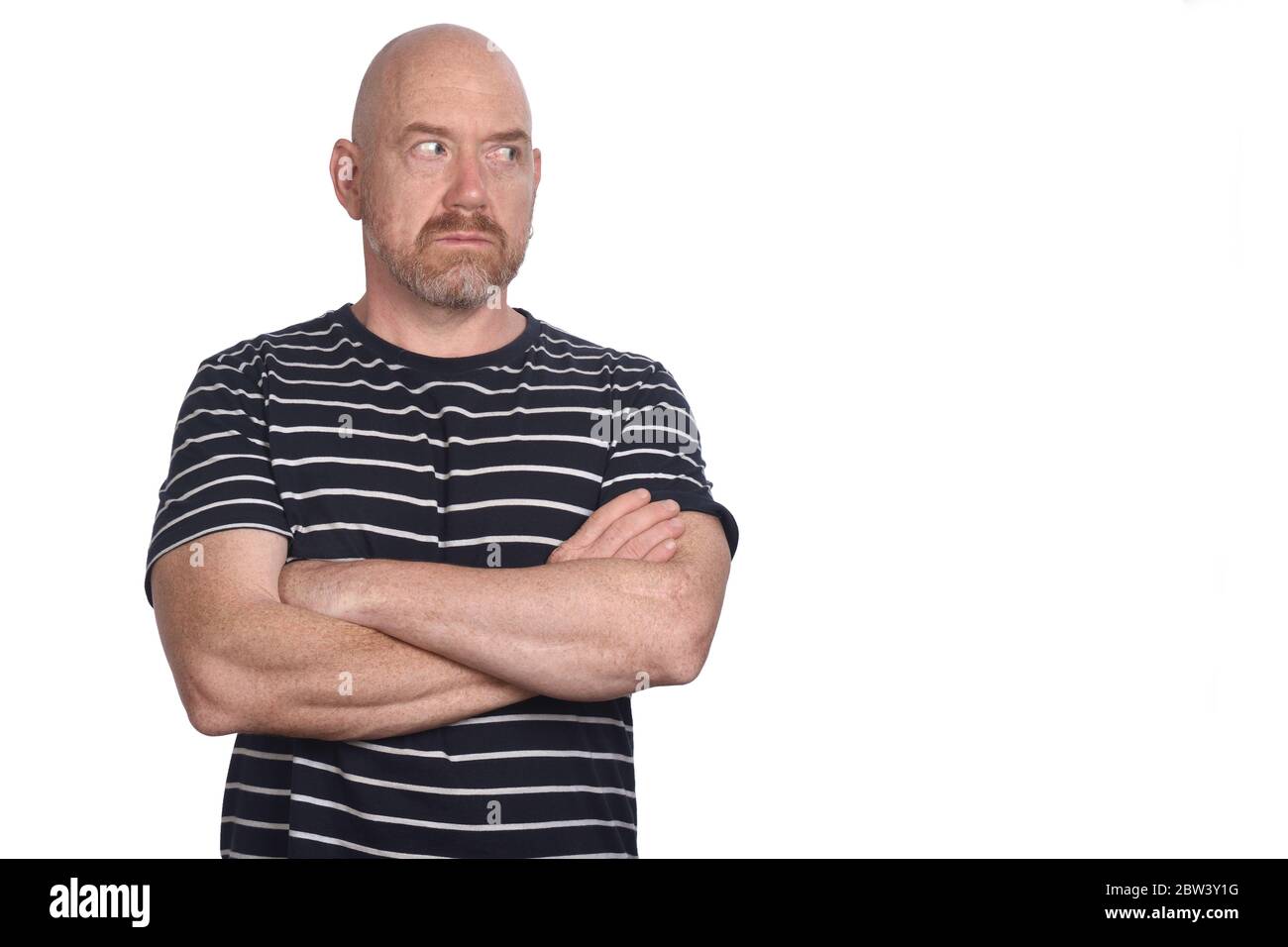 portrait of a man with arms crossed looking side on white background ...
