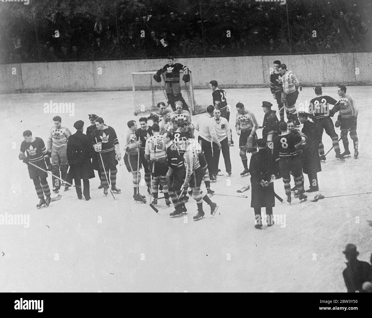 New York Ice hockey match ends in free fight , Police intervene . A free fight , in which a squad of police were forced to intervene to restore order , marked the ice hockey match between the New York Americas , and Toronto Maple Leafs at the Madison Square Gardens , new York . The Americans defeated the Maple Leafs 3 - 1 . Photo shows , police restoring order among the players on the ice at Madison Square Gardens . 9 March 1937 Stock Photo