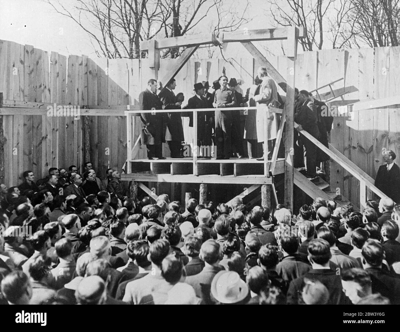 Inside picture of a murderer ' s hanging . Many people must have tried to visualise the scene as a murderer is hanged . These unusual pictures were made at Saints Genevieve , Missouri , when Hurt Hardy went smiling to the scaffold for the killing of his sweetheart . A considerable crowd watched the execution . Photo shows , Hurt Hardy smiles at his executioners and the solemn crowd below a moment before the trap was sprung . 6 March 1937 Stock Photo