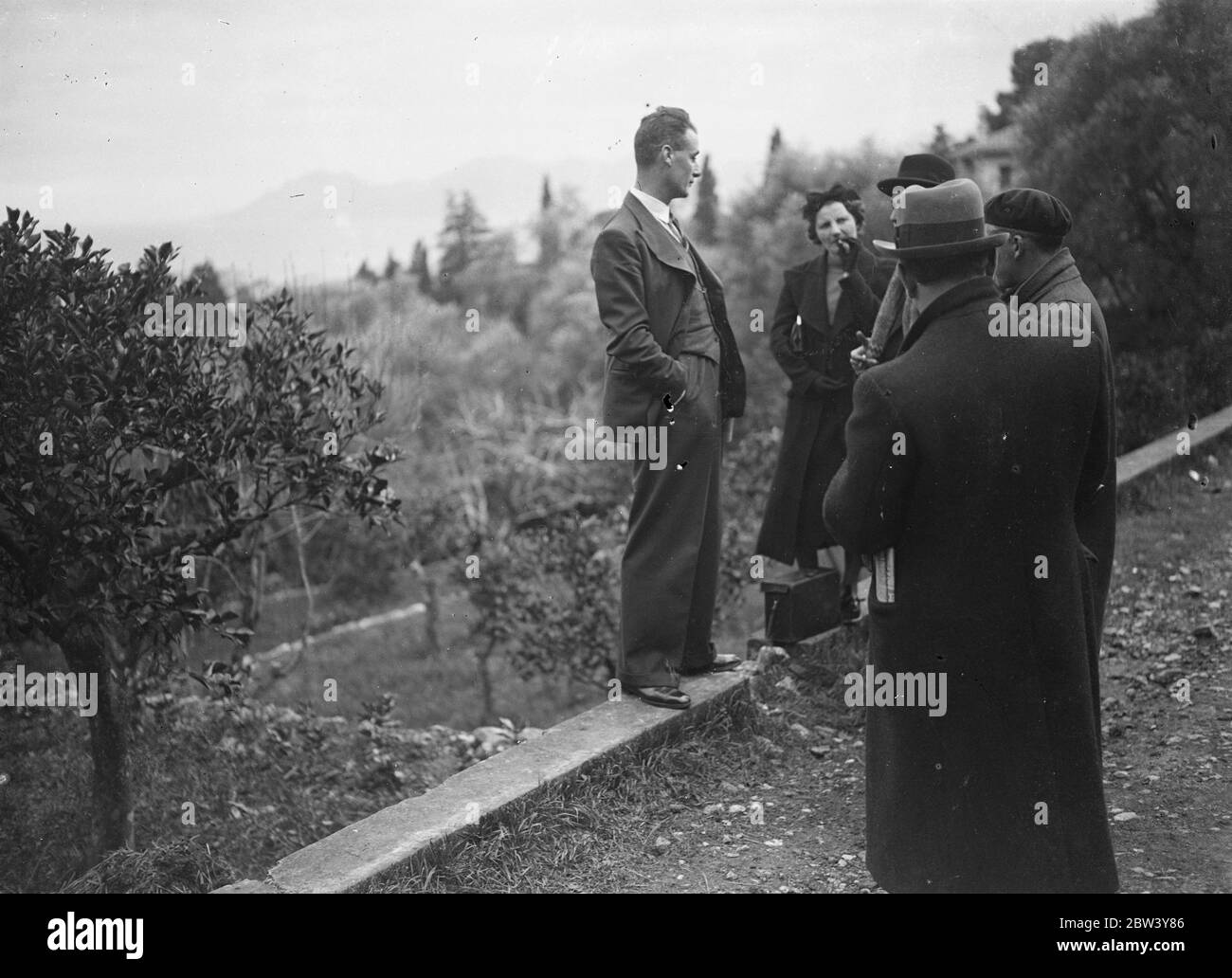 Mrs Simpson's only bodyguard interviews callers after the abdication news. King Edward's personal detective. Now that French detectives are being withdrawn from the Villa Lou Vici, Miss Wallis Simpson's Cannes retreat, Inspector Evans one of King Edward's personal detectives, is left as Mrs Simpson's sole bodyguard. Photo shows: Inspector Evans, Mrs Simpsons bodyguard, interviewing callers at the entrance to the Villa Lou Vici after the announcement of the abdication. 11 December 1936 Stock Photo