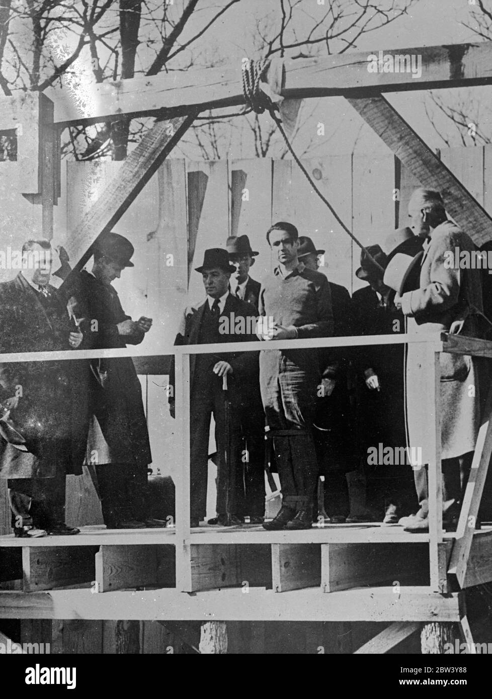 Inside picture of a murderer ' s hanging . Many people must have tried to visualise the scene as a murderer is hanged . These unusual pictures were made at Saints Genevieve , Missouri , when Hurt Hardy went smiling to the scaffold for the killing of his sweetheart . A considerable crowd watched the execution . Photo shows , Hurt Hardy ( in sweater ) just before the rope was fixed about his neck . 6 March 1937 Stock Photo