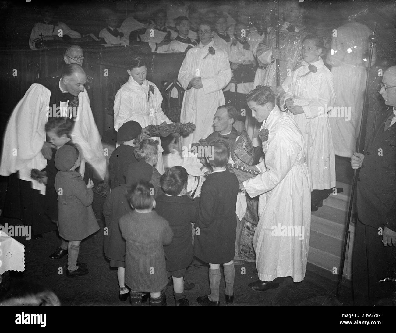 Children present violets to mothers at ' Mothering Sunday ' service . Gifts of violets and traditional simnel cake were given by children to their mothers at the annual ' Mothering Sunday ' service at St Mark ' s Church , Notting Hill . The violets were handed to the children by the Vicar , the Rev B G Chandler , and they in in turn presented them to their mothers . Photo shows , the vicar , Rev B G Chandler handing the violets to the children at the altar rails . 7 March 1947 Stock Photo