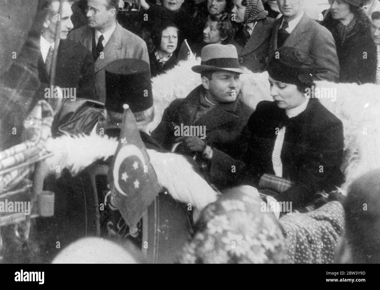 King Farouk on holiday at St Moriz. 16-year-old King Farouk of Egypt, accompanied by his mother Queen Nazli, is spending a winter sports holiday at St Moritz during his European tour. Later he will come to England to study conditions and will stay for the the Coronation. Photo shows: King Farouk and his mother, Queen Nazili, driving through St Moritz. 5 March 1937 Stock Photo