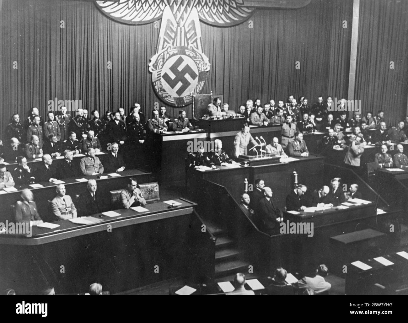 Adolf Hitler pledges European safety answers to Anthony Eden and scraps Versailles clauses in Reichstag speech . A page of safety for France and Belgium , and repeated demand for the return of Germany ' s colonies , and the scrapping of two more clauses of the mutilated the Versailles treaty where the main points of Chancellor Hitler ' s anxiously awaited speech to the Reichstag in Kroll Opera house , Berlin , on the fourth anniversary of the Nazi regime . He devoted considerable time to answering Anthony Eden's recent speech in which the British Foreign Minister appealed to Germany . Followin Stock Photo
