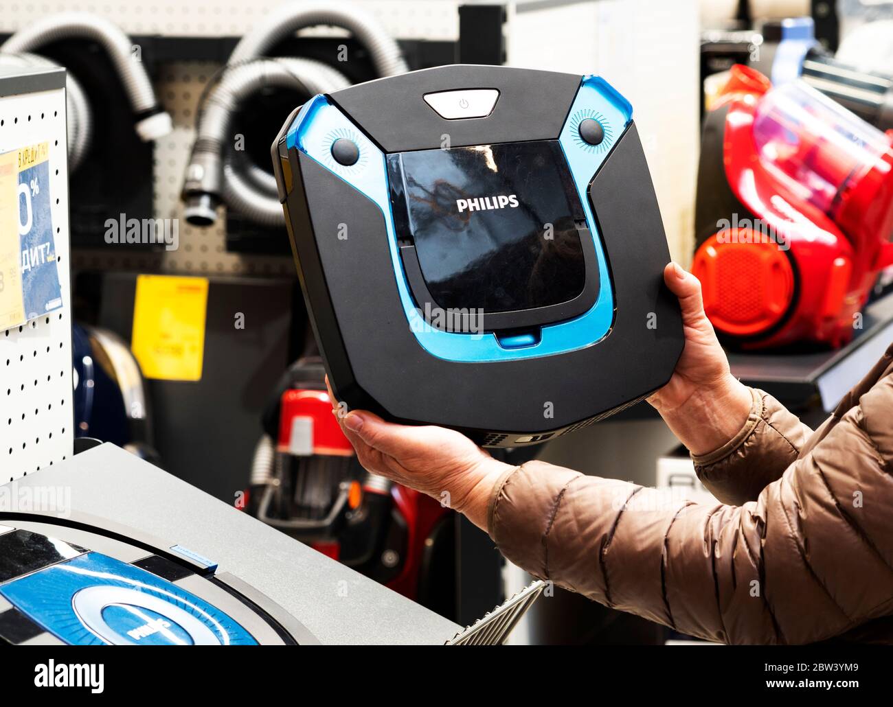 A woman holds a Philips robot vacuum cleaners in store Stock Photo - Alamy