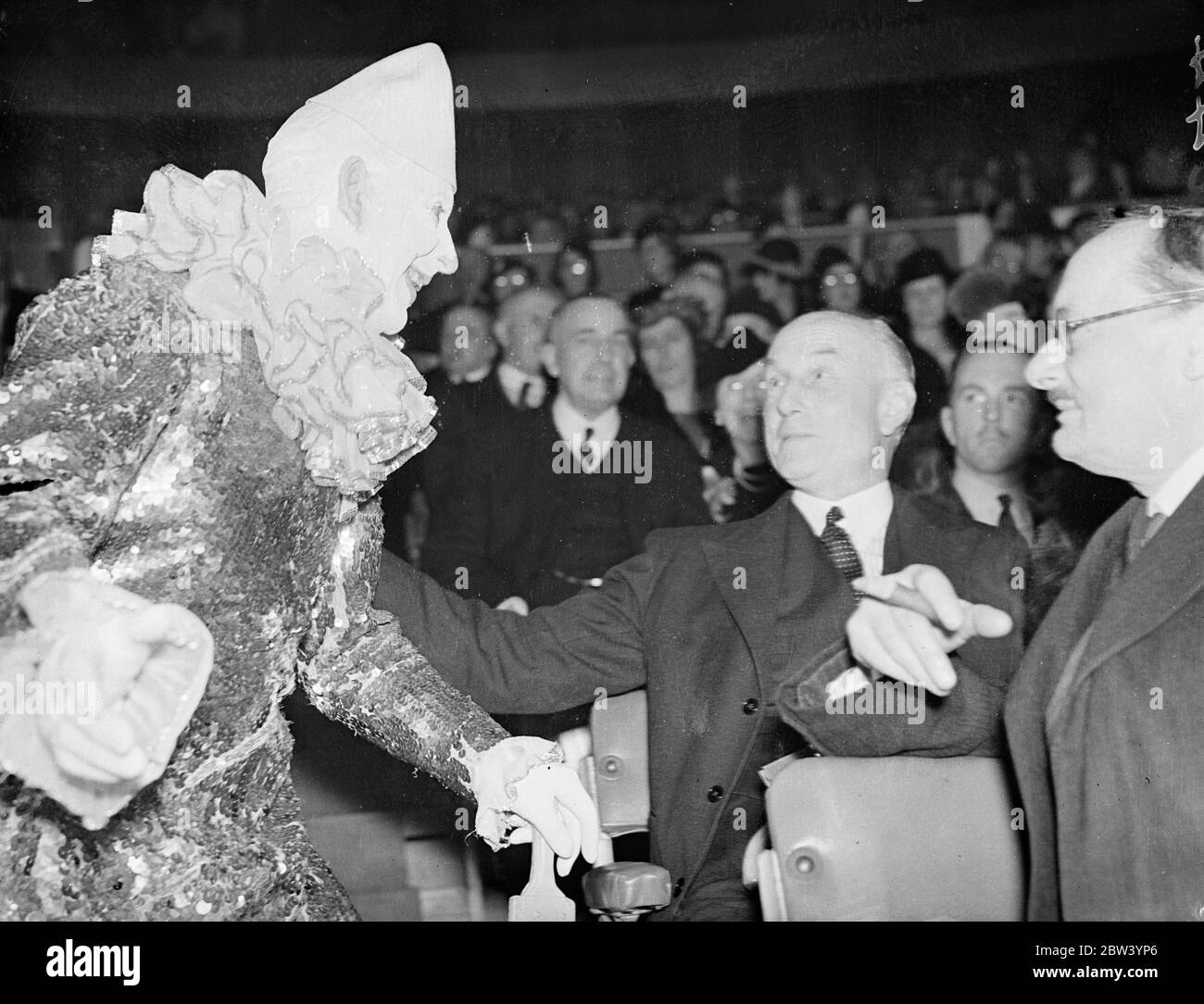 First Lord and the clown. Opening of the Olympia Circus. Cabinet Ministers and the Lord Mayor, Sir George Broadbridge, attended the opening of Bertram Mills' Christmas Circus at Olympia, London. Photo shows: Sir Samuel Hoare, first Lord of the Admiralty, chatting to a clown at the Circus. 22 December 1936 Stock Photo