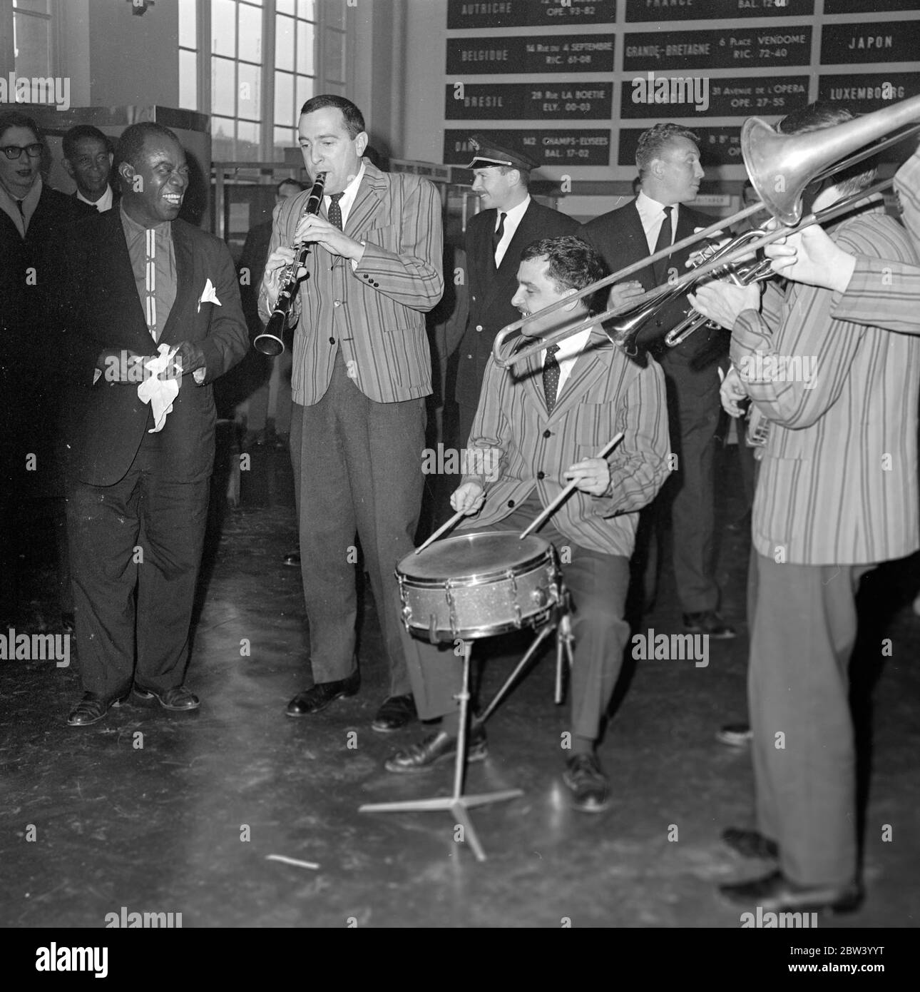 Louis Armstrong in Paris . The King of jazz , the celbrated Louis Armstrong and his orchestra have arrived this morning in Paris from Abidjan , on the last step of his journey from Africa . Louis Armstrong is in Paris to appear in ' Paris Blues ' alongside Paul Newman , Joanne Woodward and Sydney Poitier , under the direction of Martin Ritt . After their arrival from Orly here are Louis Armstrong and Velma Middleton surrounded by the musicians of the Mowgli Jospin High Society Jazz Band who came to play at the Paris Airport . 5 December 1960 Stock Photo