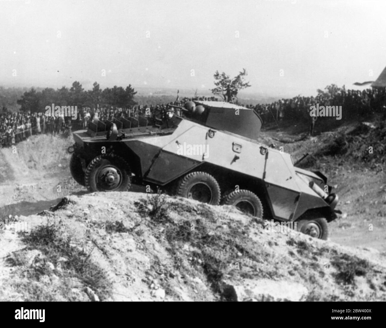An eight wheeled armoured car demonstrated in Austrian army manoeuvres . A new type of 8 wheeled armoured car capable of surmounting the worst obstacles and maintaining a fair speed over the roughest ground , was demonstrated at the Austrian army manoeuvres near Bruck . Each of the eight wheels is independently sprung , enabling the car to maintain an even keel over the worst ground . Photo shows , the eight wheeled armoured car climbing over rough grounds at the Bruck military camp watched by a crowd . 22 September 1936 Stock Photo