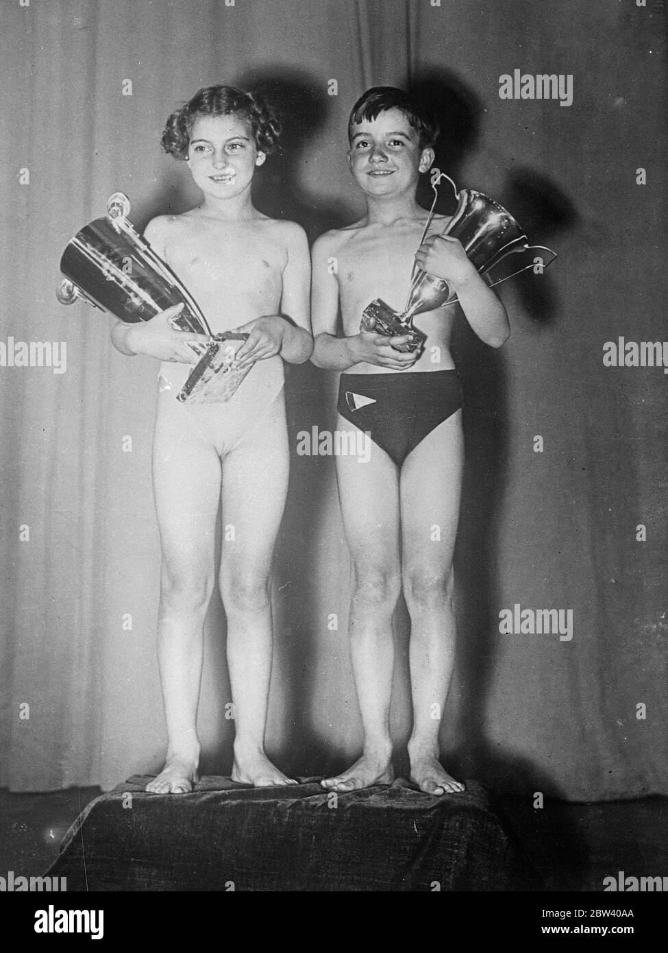 Most beautiful children in France . Henry Barbet , aged 9 1/2 , and Suzanne Cazenove , aged 9 , was selected as the most beautiful boy and girl in France as a contest in Paris . Photo shows Suzanna Cazenove ( left ) and Henry Barbet with their cups . 12 April 1937 Stock Photo