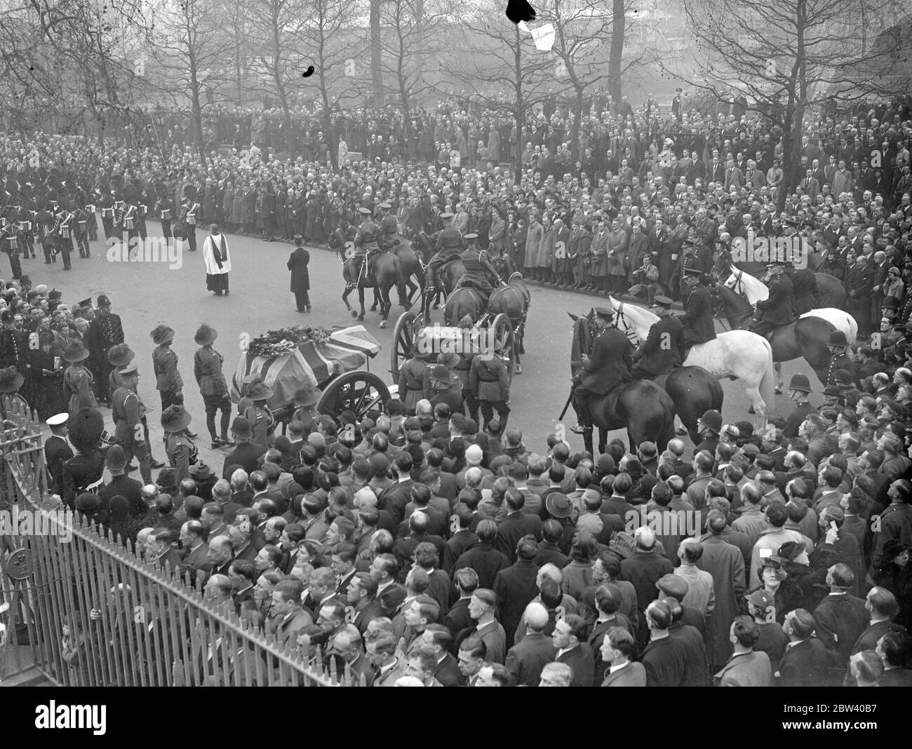 Funeral of Australian VC in London . Full military honours . With full military honours , the body of Gunner A P Sullivan , the Australian VC , was taken from Wellington Barracks , to Golders Green for cremation . Gunner Sullivan , a member of the Australian Coronation contingent , was knocked down and killed by a cycle last week . Photo shows , the funeral cortege passing through the crowds outside Wellington Barracks . 13 April 1937 Stock Photo