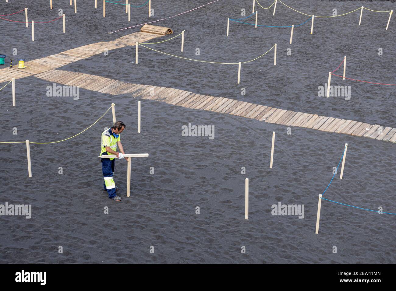 Workers prepare the beach with cordoned off areas to maintain social distancing, two metres apart, and controlled access for the public during Phase t Stock Photo