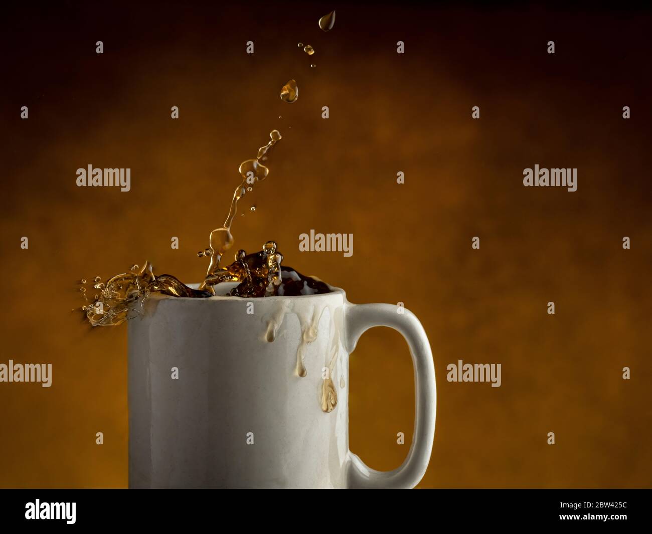 Coffee splashing out of coffee mug Stock Photo