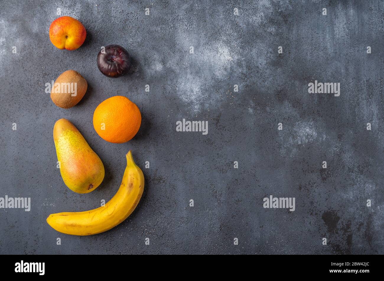 Ingredients for fruit salad on a dark wooden surface. Top view. Copy space for text Stock Photo