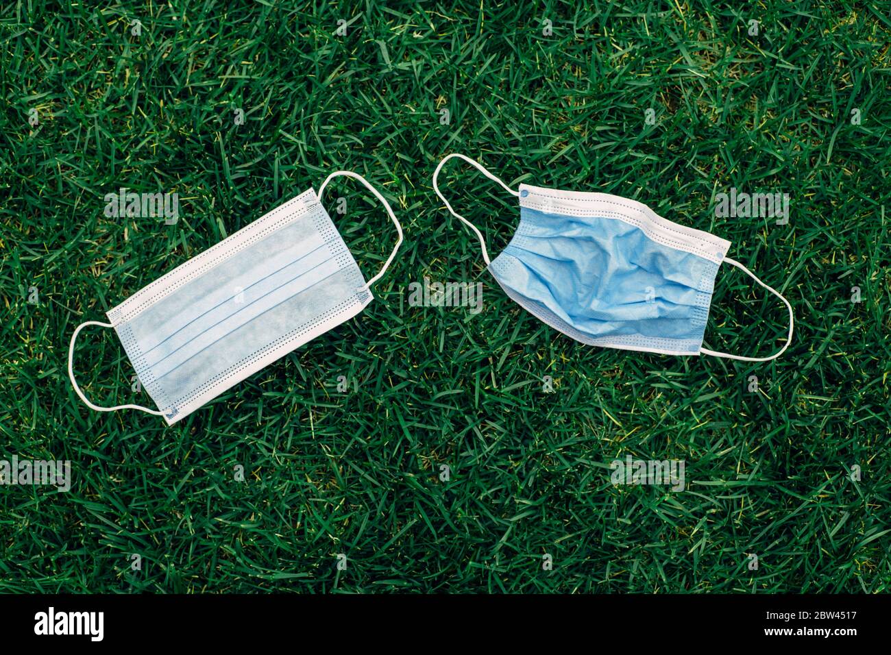 Group of used and fresh sanitary masks lying on grass. Disposable